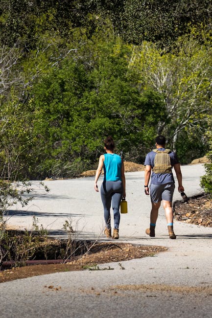 Man and woman enjoying a walk on a scenic trail surrounded by greenery.